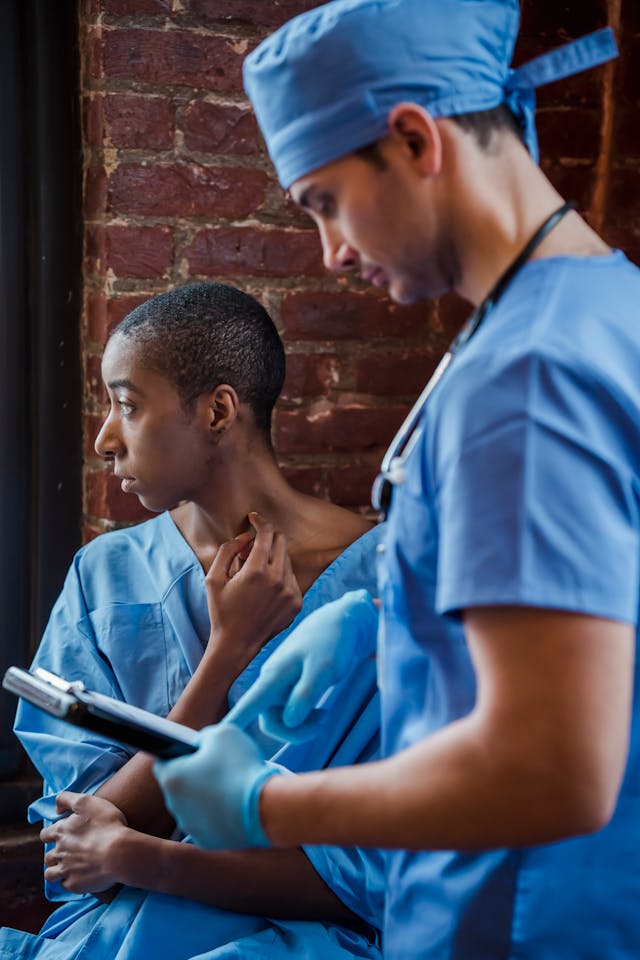 Doctor explaining diagnosis to black female patient in corridor of hospital