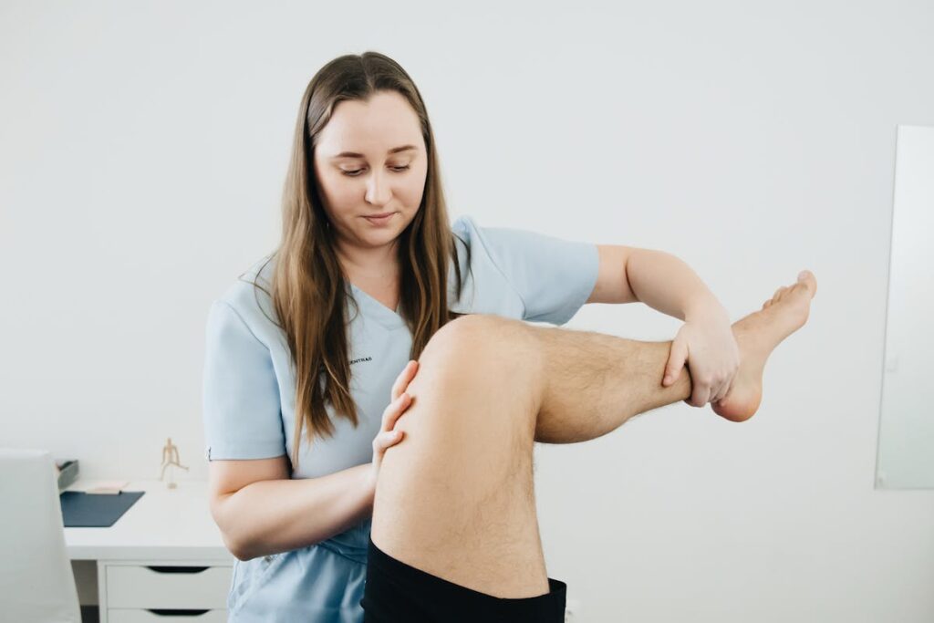 Physiotherapist Massaging Lifted Leg